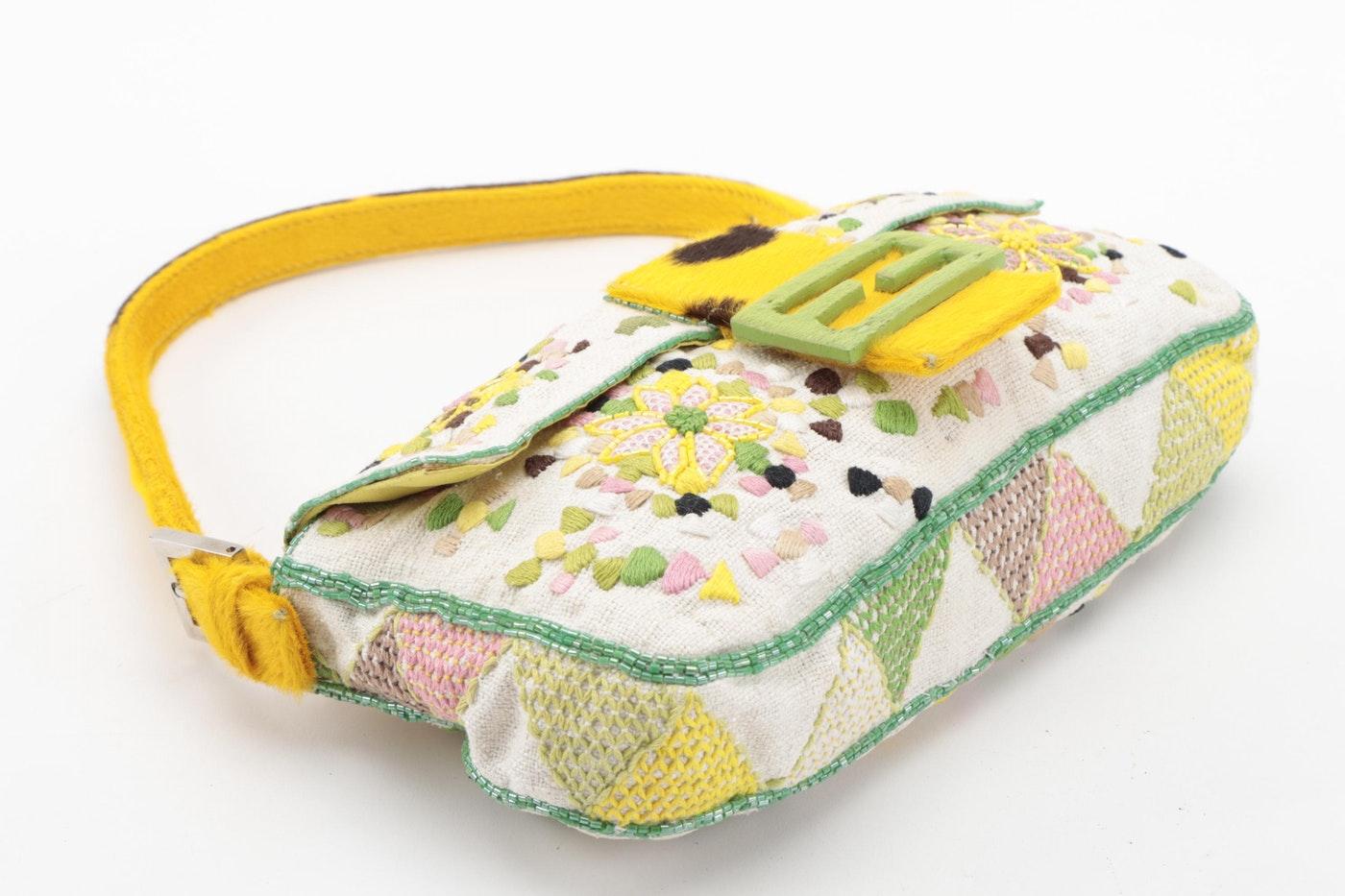 Show off this Fendi with all your looks! Circa late 1990s, this unique Fendi baguette is crafted from woven canvas and features a colorful floral and geometric appliqué pattern with beading around the trim. Includes silver hardware and a yellow pony