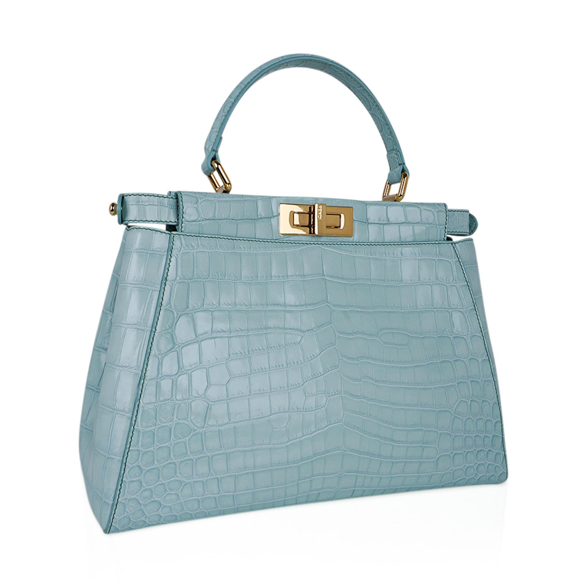 Mightychic offers a Fendi Peekaboo Crocodile bag featured in Mint (Pale Ice Blue).
This beautiful pastel medium Peekaboo bag is on trend for the season!
Modified top frame with gold hardware on each side.
This creates a large compartment on each