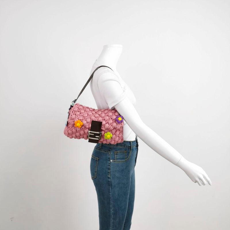 Fendi Baguette Bag Pink Crochet Knit Wool Pompom and Flowers Shoulder Bag
  These are professional photos of the actual bag offered by Luxbags.
  This Fendi Baguette in Pink wool with pompoms are super cute. It‚Äôs a great winter accessory. 
 