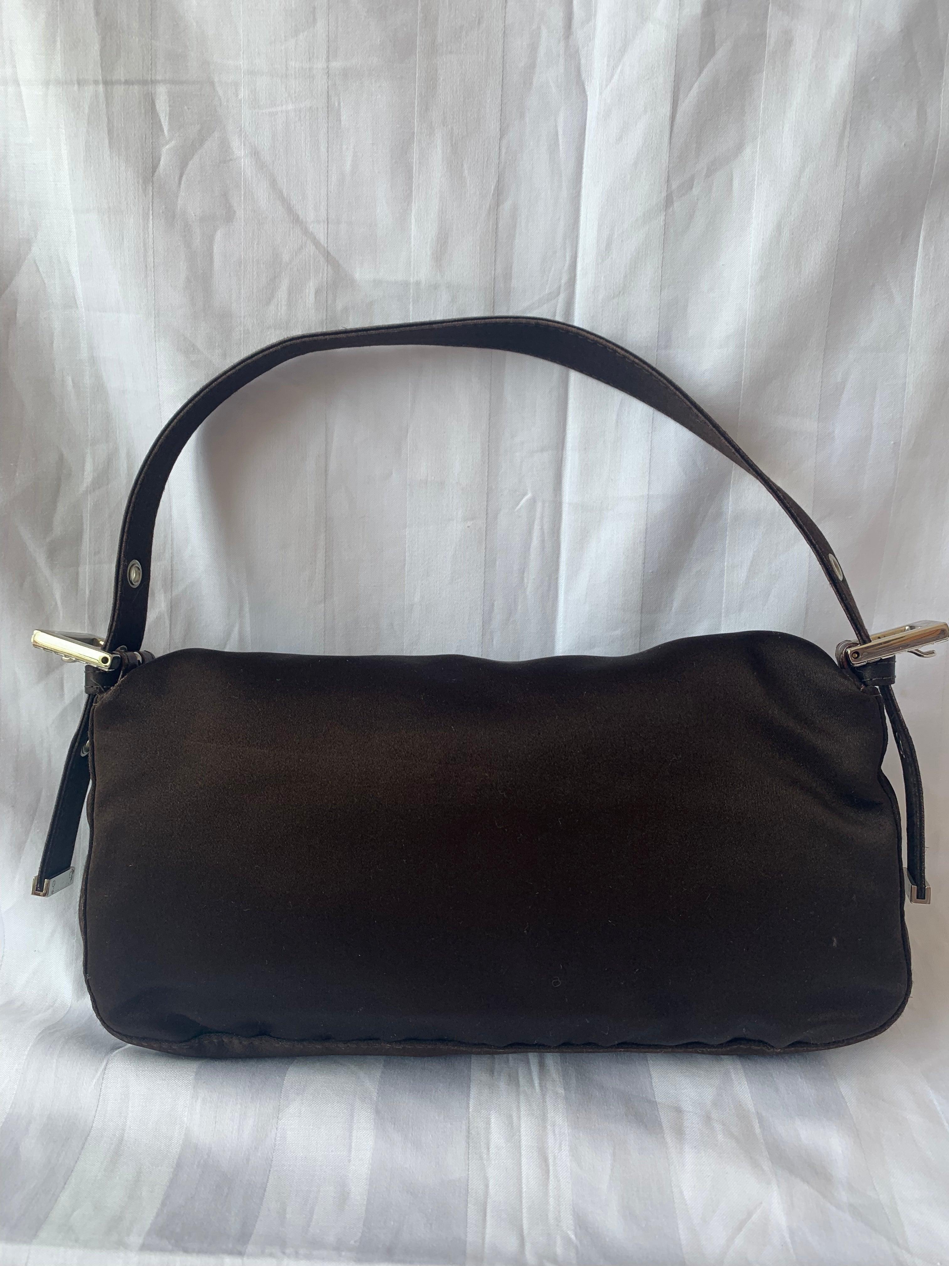 FENDI Baguette Black Silk with Crystal Buckle
 These are professional photos of the actual bag offered by Luxbags.
 Introducing the timelessly elegant FENDI Baguette in Black Silk with Crystal Buckle! In very good condition, this classic piece is