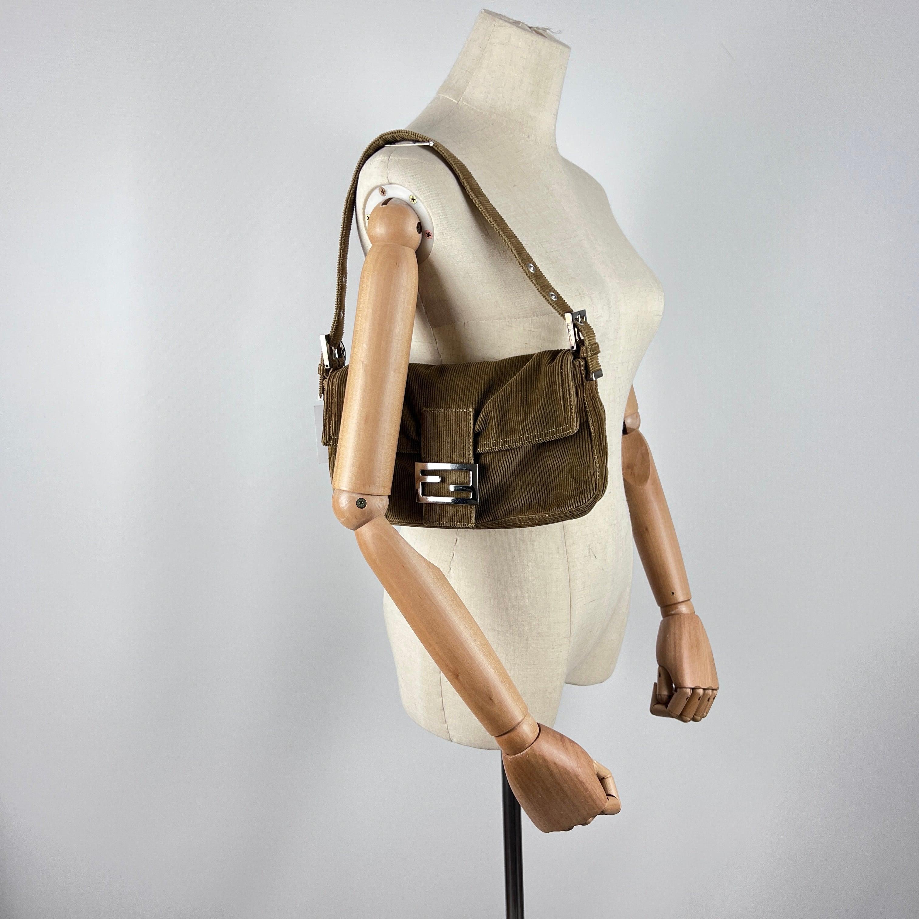 Magnificent Fendi Baguette in brown suede with silver-tone hardware. Compact flap silhouette and refined interior detailing. A 1990s creation by Silvia Venturini Fendi, representing one of the most recognizable icons in fashion history.