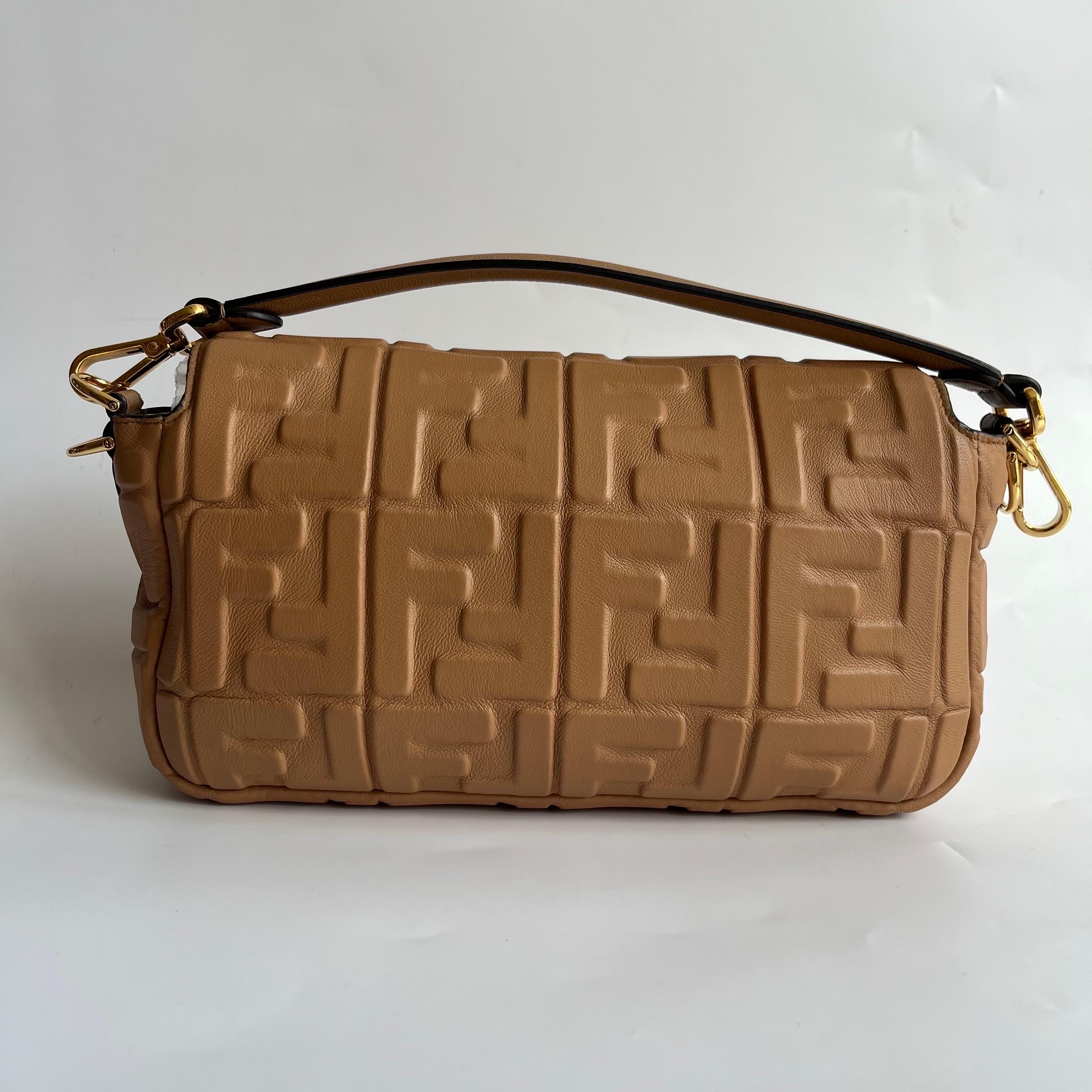Experience luxury and style with the Fendi Baguette in luxuriously Nappa Leather Crossbody Bag. Crafted from soft nappa leather with intricate 3D FF motif embossing, this incredibly light bag offers both functionality and fashion. Carry it by hand,