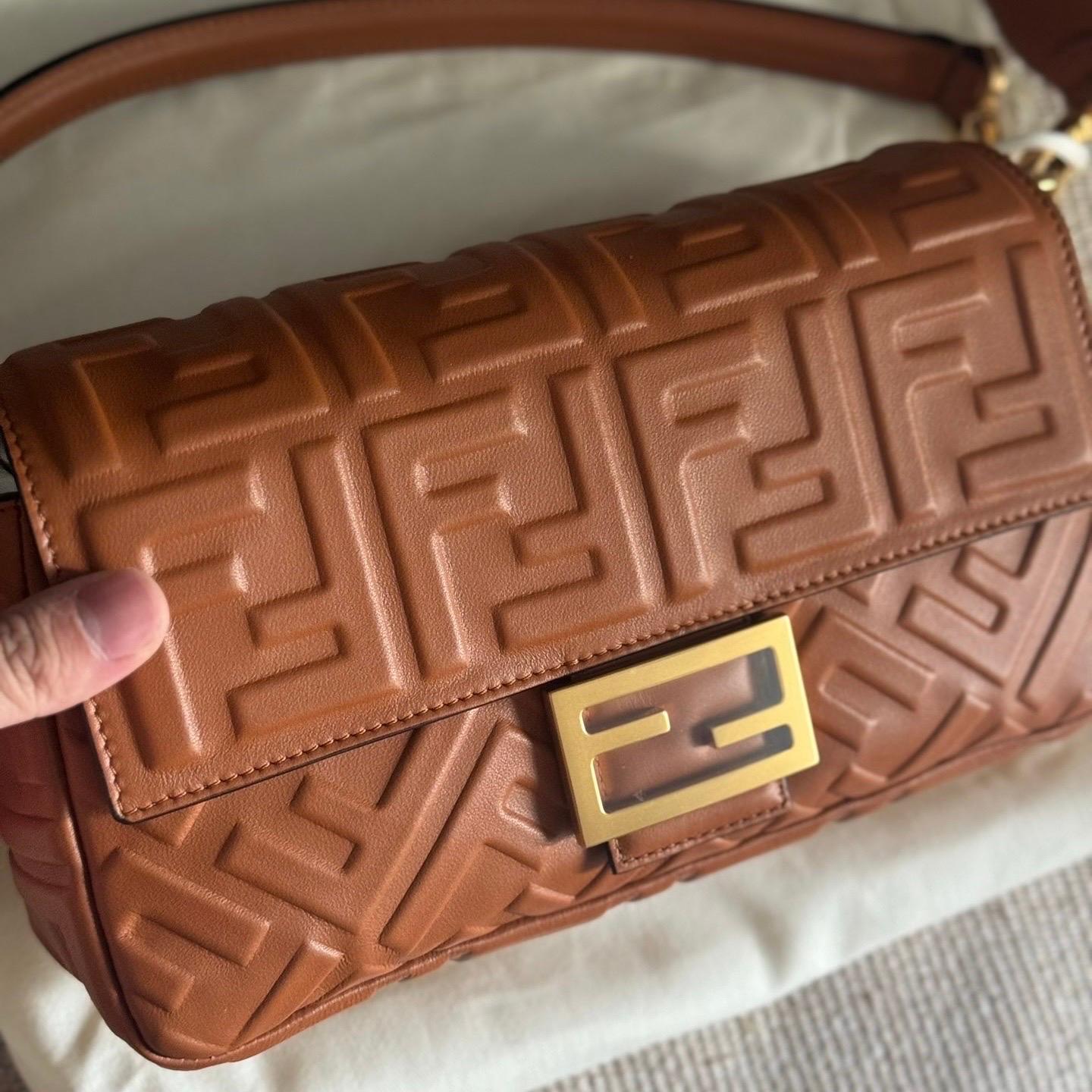 Experience luxury and style with the Fendi Baguette in luxuriously Nappa Leather Crossbody Bag. Crafted from soft nappa leather with intricate 3D FF motif embossing, this incredibly light bag offers both functionality and fashion. Carry it by hand,