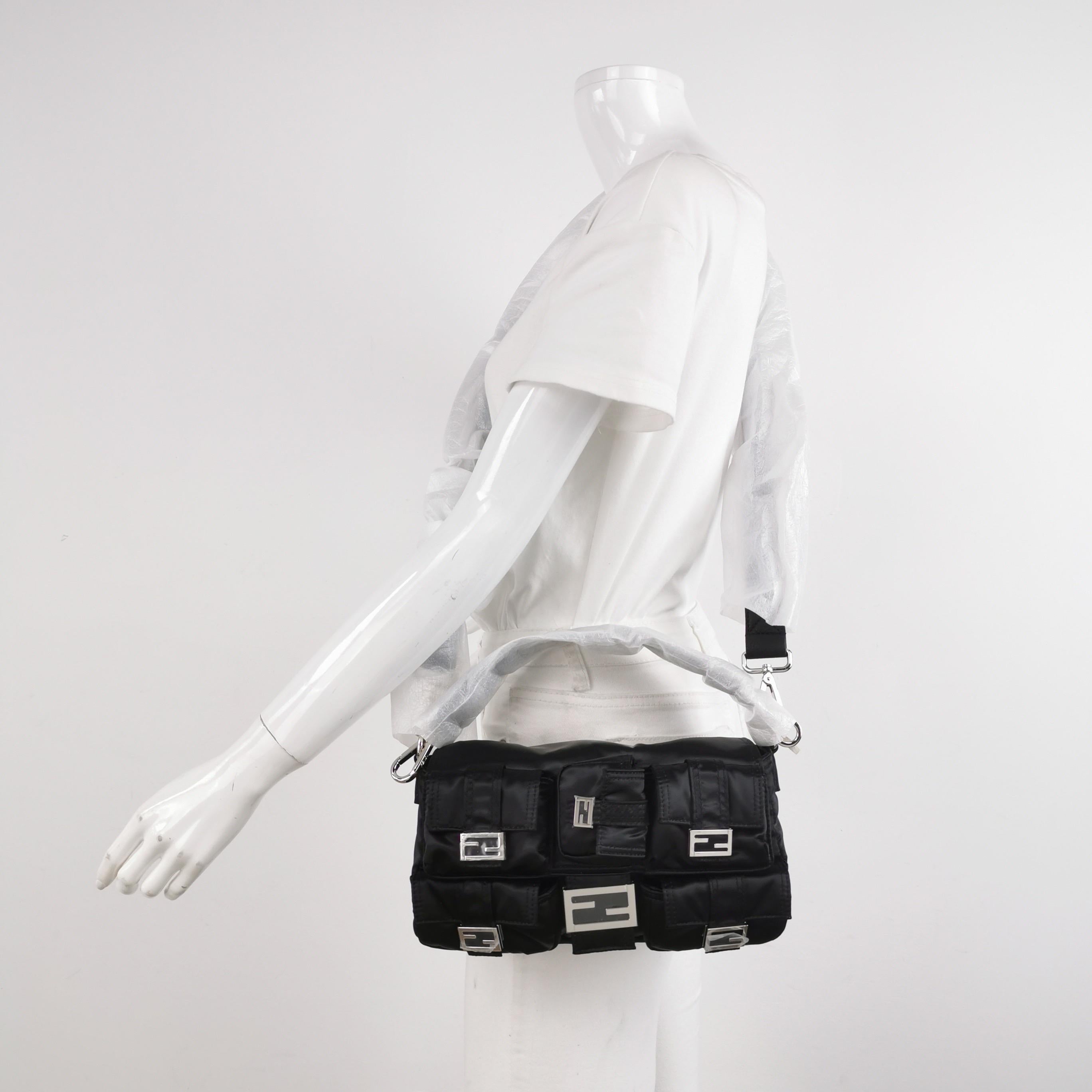 

Le sac Fendi allie sans effort sophistication intemporelle et praticité. Fabriqué en nylon noir durable, il comporte plusieurs poches pour une organisation sans faille. La forme baguette emblématique est ornée d'une quincaillerie élégante et d'un