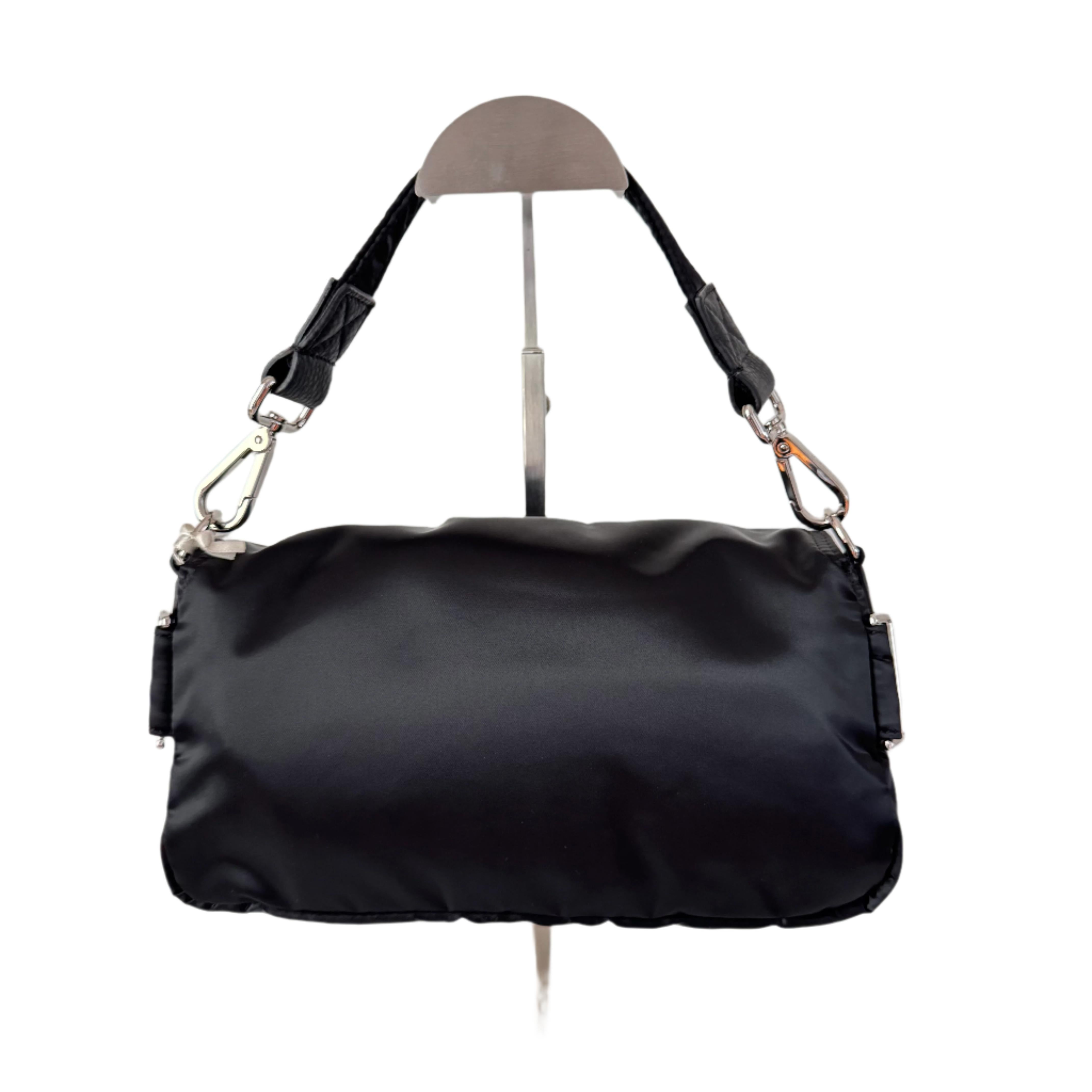 

Die Tasche von Fendi verbindet mühelos zeitlose Raffinesse mit praktischer Funktionalität. Sie ist aus strapazierfähigem schwarzem Nylon gefertigt und verfügt über mehrere Taschen für eine nahtlose Organisation. Die kultige Baguette-Form ist mit