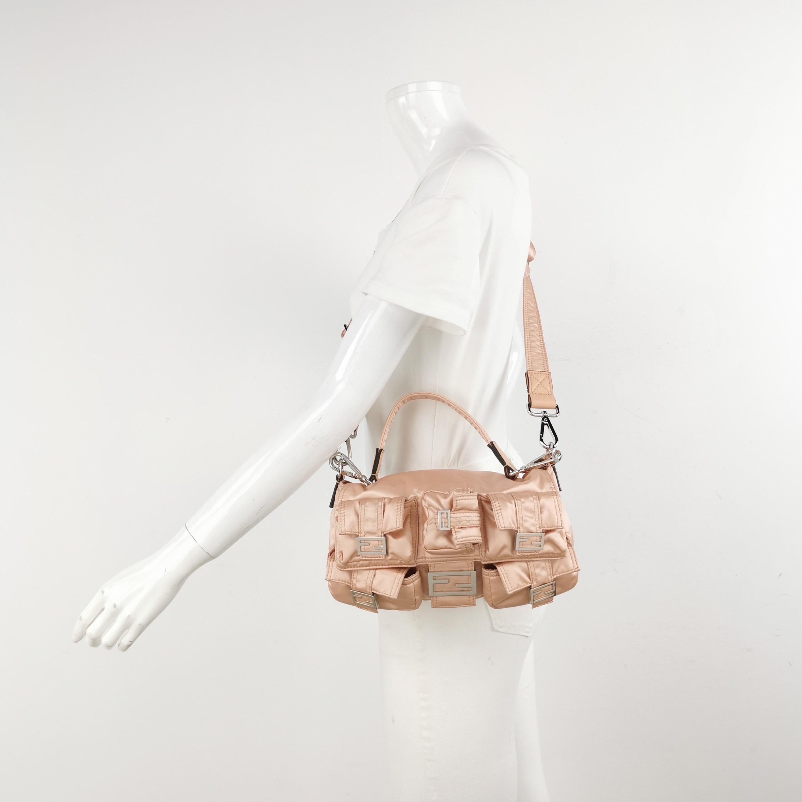 Le sac Fendi allie sans effort sophistication intemporelle et praticité. Fabriqué en nylon rose durable, il comporte plusieurs poches pour une organisation sans faille. La forme baguette emblématique est ornée d'une quincaillerie élégante et d'un