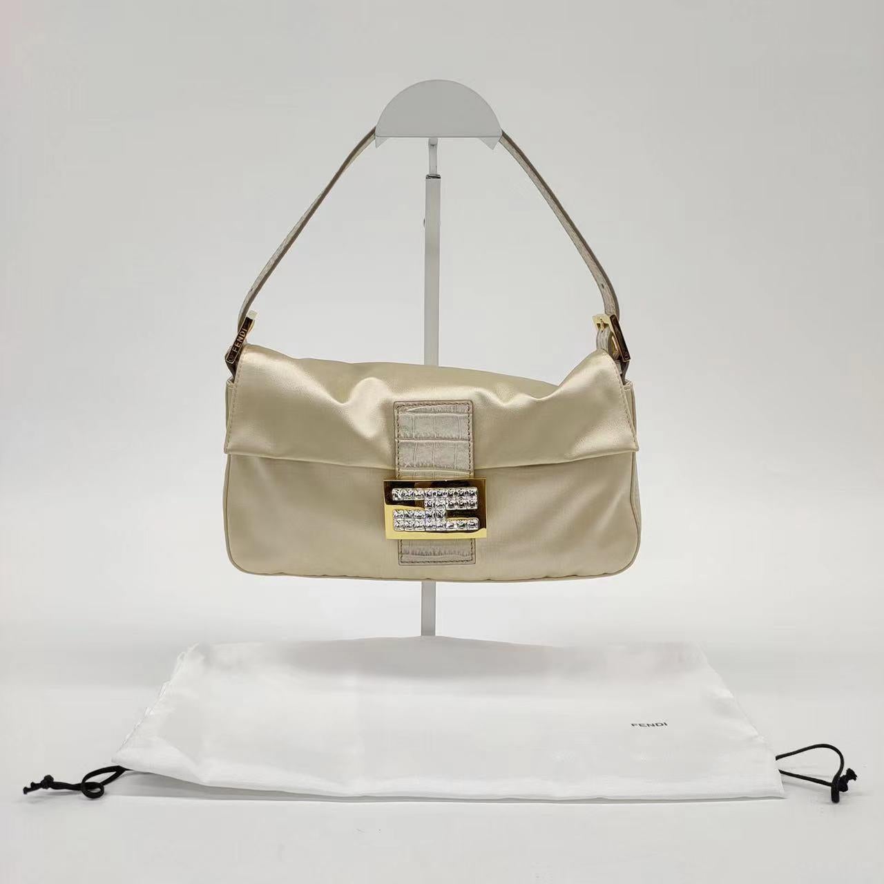 FENDI Baguette Cream Biege Silk with Crystal Buckle
 These are professional photos of the actual bag offered by Luxbags.
 Introducing the timelessly elegant FENDI Baguette in Creal / Biege Silk with Crystal Buckle and crocodile leather. In very good