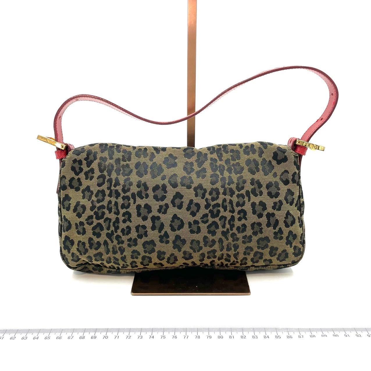 Fendi Baguette Denim Leopard Print with Red Leather Rare
These are professional photos of the actual bag.
  This rare Fendi Baguette combines a wild leopard print, bold red leather and gold-tone hardware for a striking aesthetic. The holy grail
