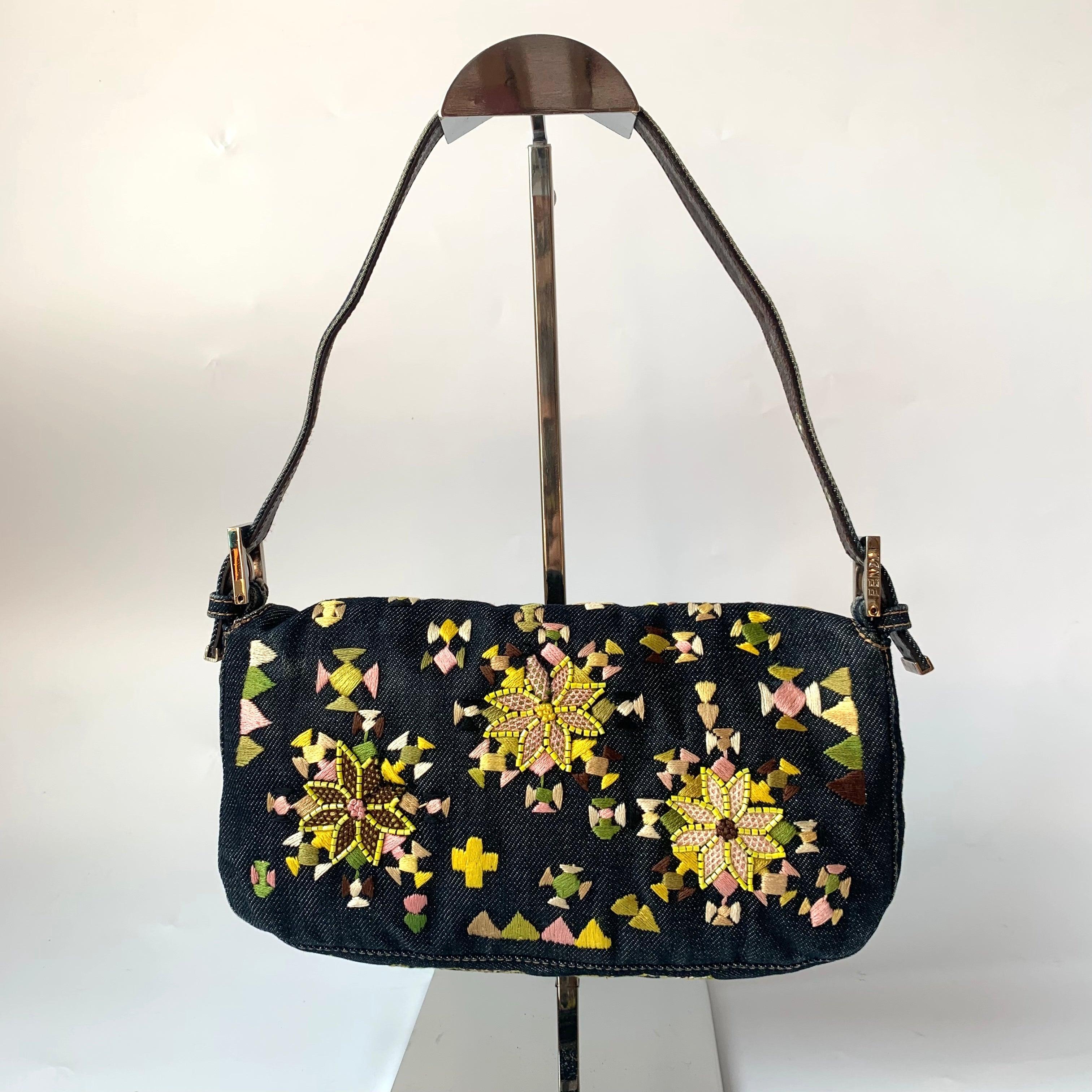 Fendi Baguette Denim with Floral Embroidery
These are professional photos of the actual bag.
  CONDITION: VERY GOOD
  DETAILS
  
  Fendi
  Baguette
  Denim
  Pink satin lining
  Silver hardware
  Standard size
  Width 27cm x Height 15.5cm x Depth 7cm