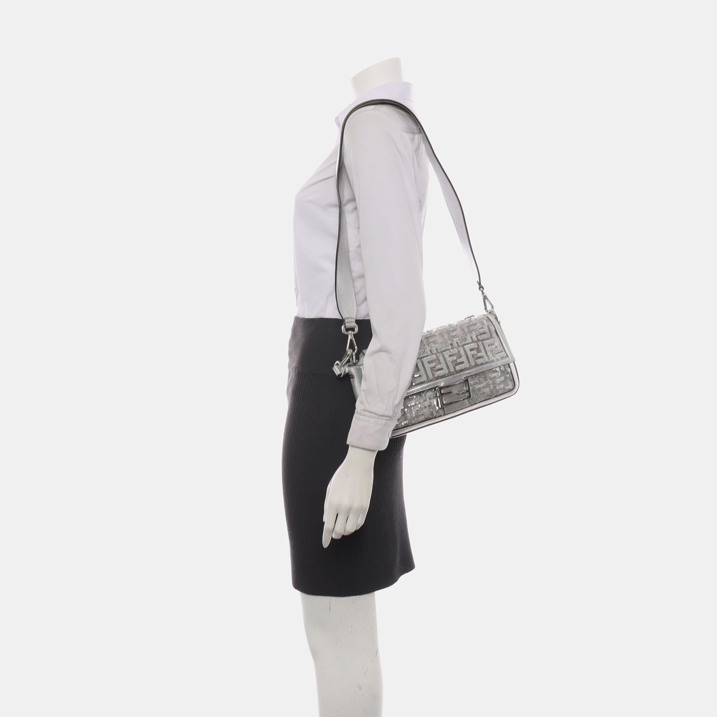 Experimenta el lujo y el estilo con el bolso cruzado Fendi Baguette en PVC plateado y piel, raro y exquisito. Este bolso increíblemente ligero, fabricado en PVC y piel con un intrincado motivo FF en relieve 3D creado con lentejuelas plateadas,