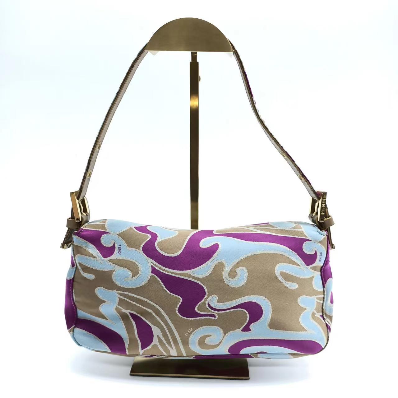 FENDI Baguette Multicolor Purple Fabric with Psychedelic prints
These are professional photos of the actual bag.
  Introducing the timelessly elegant FENDI Baguette in Multicolor Silk with Psychedelic prints! In very good condition, this classic