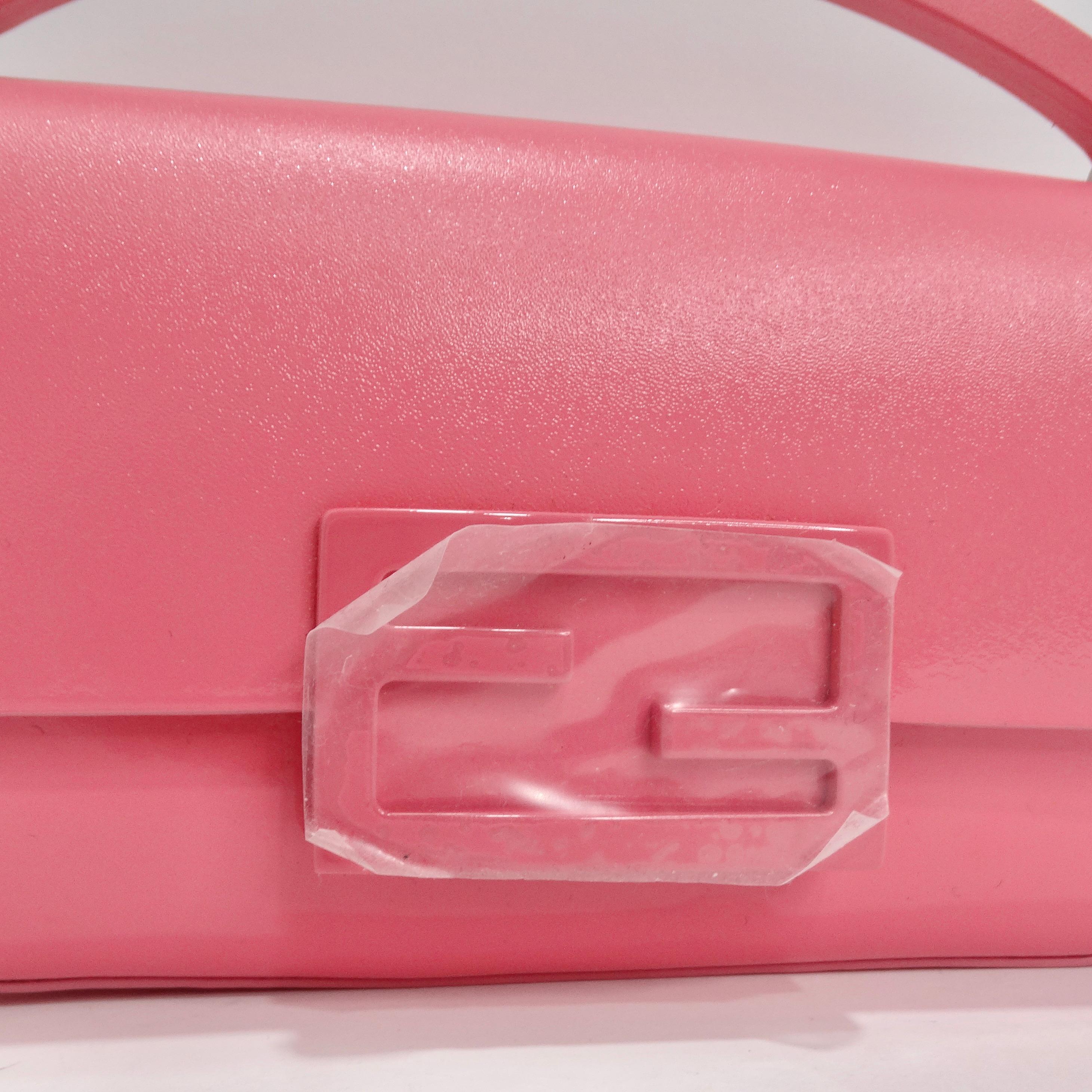 Introducing the Fendi Baguette Phone Pouch in a delightful Rose Pink patent leather, the epitome of compact and chic luxury. This Fendi Baguette Phone Pouch is a vision in rose pink patent leather, a color that exudes femininity and elegance. With