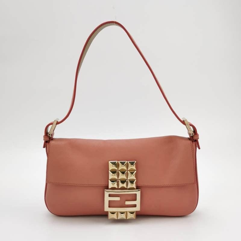 Fendi Baguette Pink Leather with Gold Studded Metal Buckle
These are professional photos of the actual bag.
  This gorgeous Fendi Baguette is made of beige leather and features an eye-catching gold studded metal buckle.
  CONDITION: EXCELLENT 
 