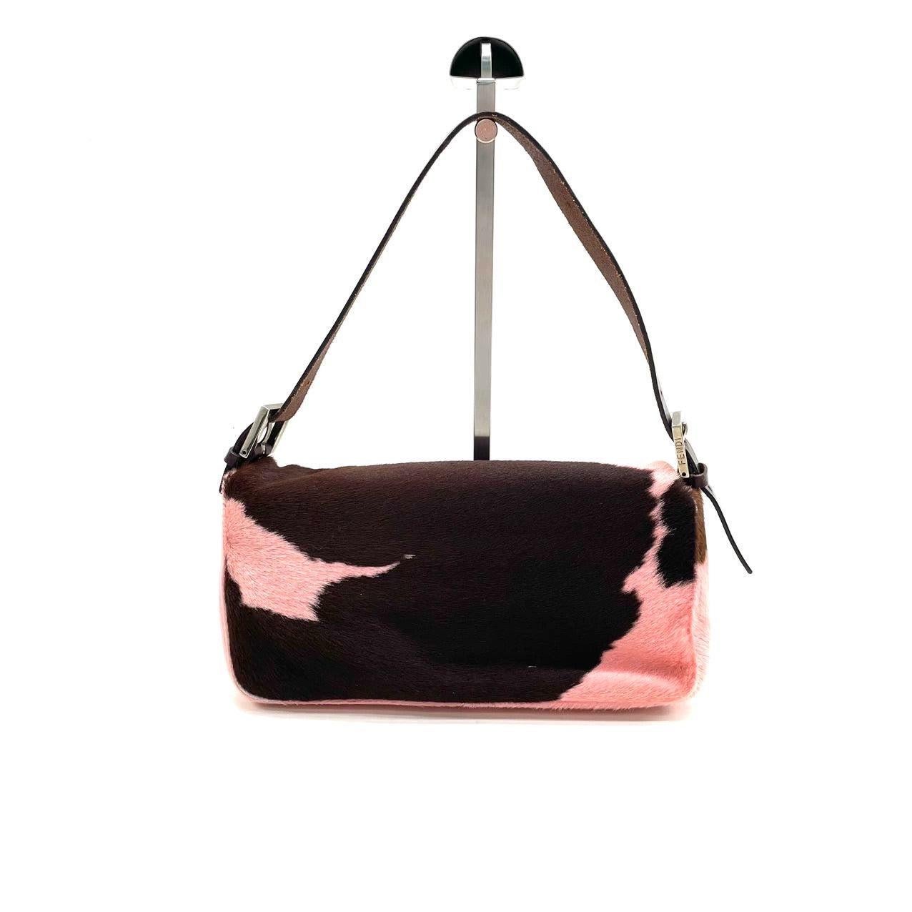 Fendi Baguette Pony-style Calfskin Leather Shoulder Bag in Pink Cow Print
 These are professional photos of the actual bag.
 Get ahead of the fashion curve with the Fendi Baguette Pony hair shoulder bag in cow print pink. Made with high-quality