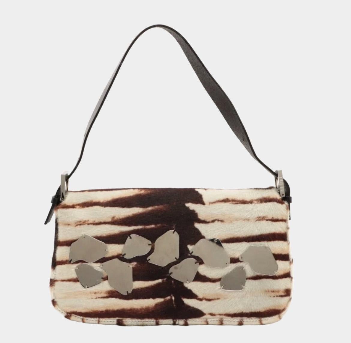 Fendi Baguette Pony-style Calfskin Leather Zebra Print with Metal Mirror These are professional photos of the actual bag offered by Luxbags. Expertly crafted from rare calfskin leather with an iconic zebra print, this Fendi Baguette is a true luxury