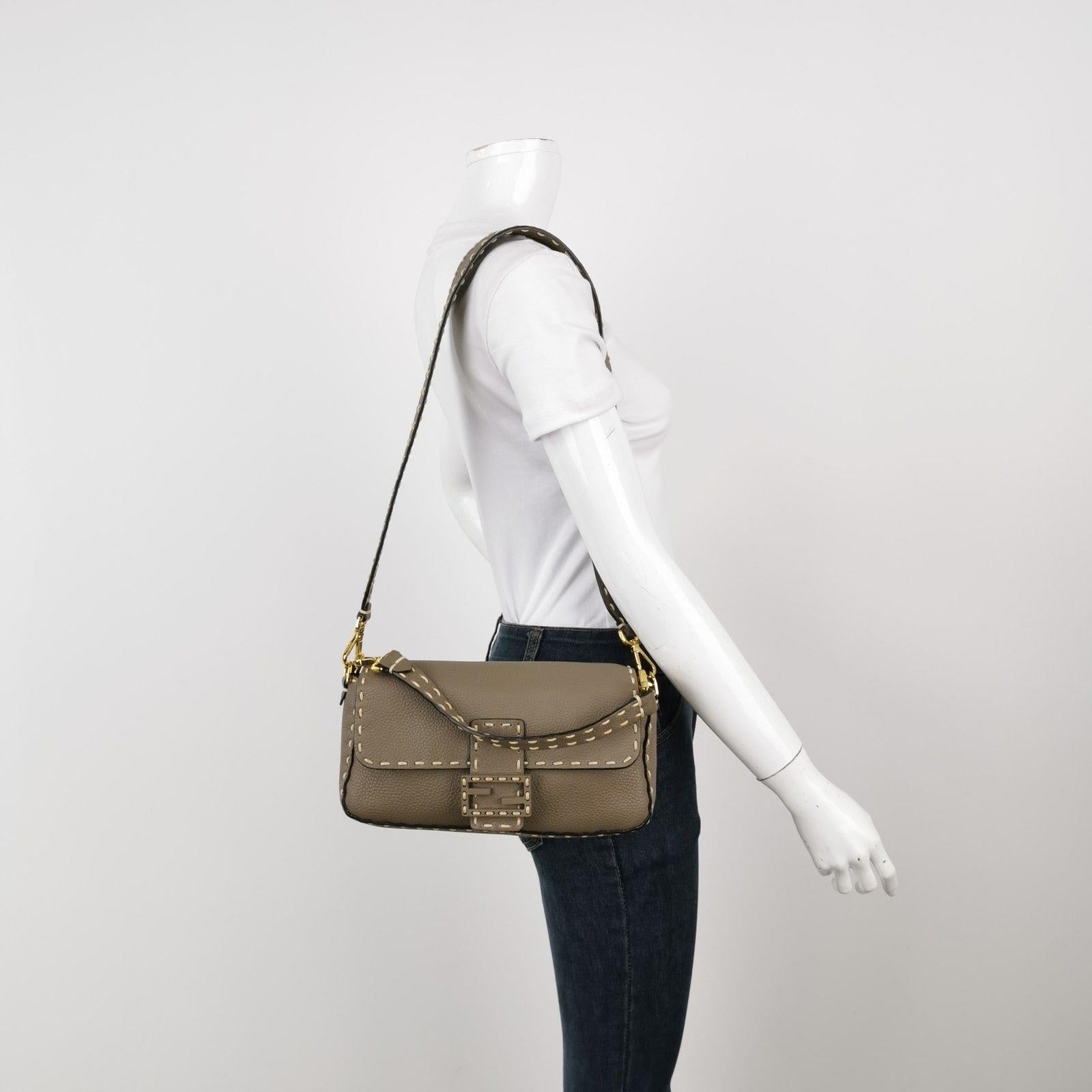 Fendi Baguette Selleria Calfskin Leather Crossbody Bag Medium Grey Beige

Experience luxury and style with the Fendi Baguette in durable calfskin Leather Crossbody Bag. Crafted from calfskin leather with selleria white stitching, this incredibly