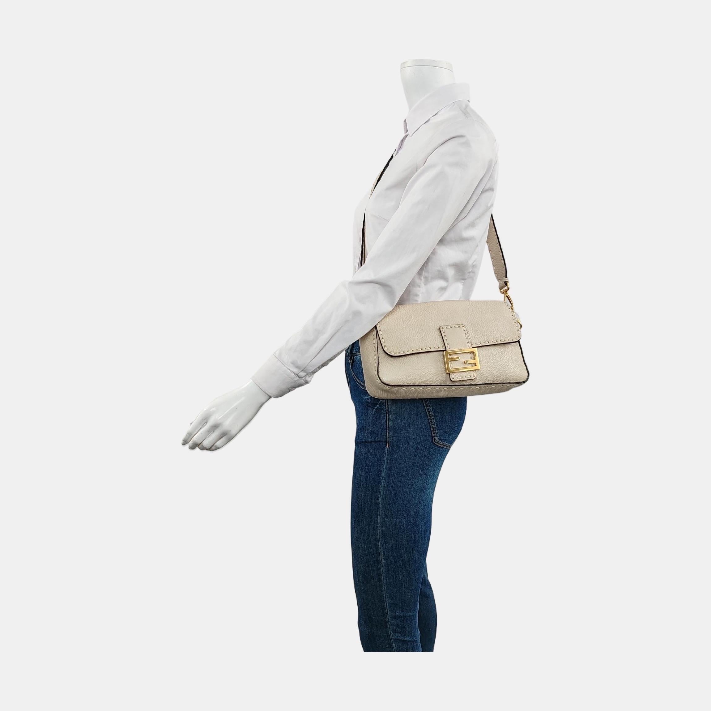 Experimenta el lujo y el estilo con el bolso cruzado Fendi Baguette en resistente piel de becerro. Fabricado en piel de becerro con pespuntes en blanco selleria, este bolso increíblemente ligero ofrece funcionalidad y moda. Llévala en la mano, al