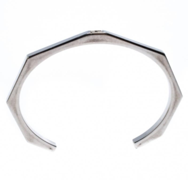 For the woman who is ready to ace every accessory game, Fendi brings her this fabulous open cuff bracelet made from silver-tone metal into a hexagonal shape. The piece has a simple style with smooth edges and a cutout of the FF logo.
