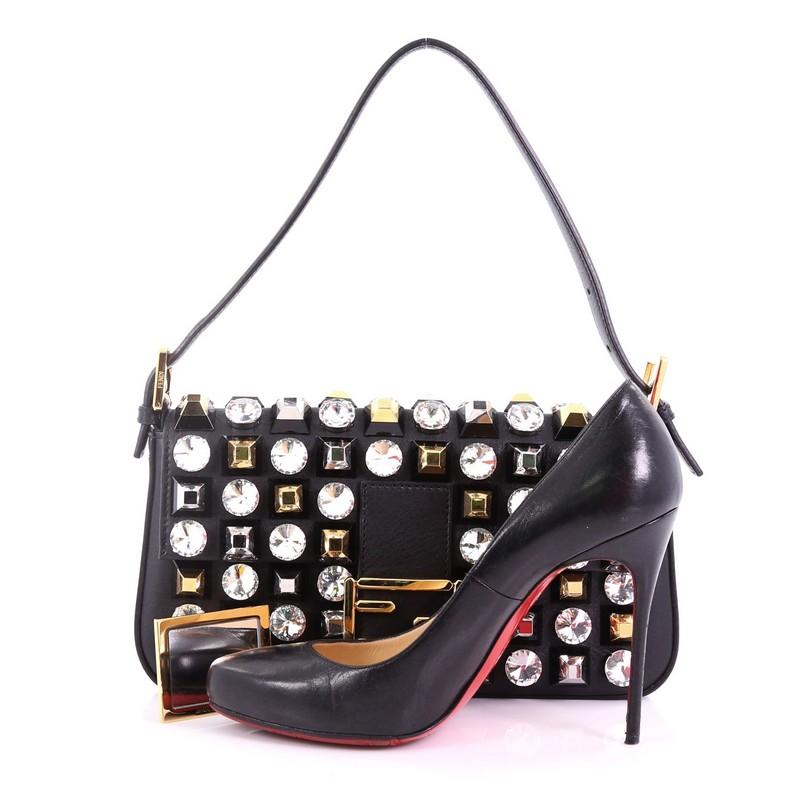 This Fendi Baguette Studded Leather, crafted from black studded leather, features  a flat leather strap, stud embellishment, signature FF logo, and gold-tone hardware. Its magnetic snap button closure opens to a black fabric interior with slip