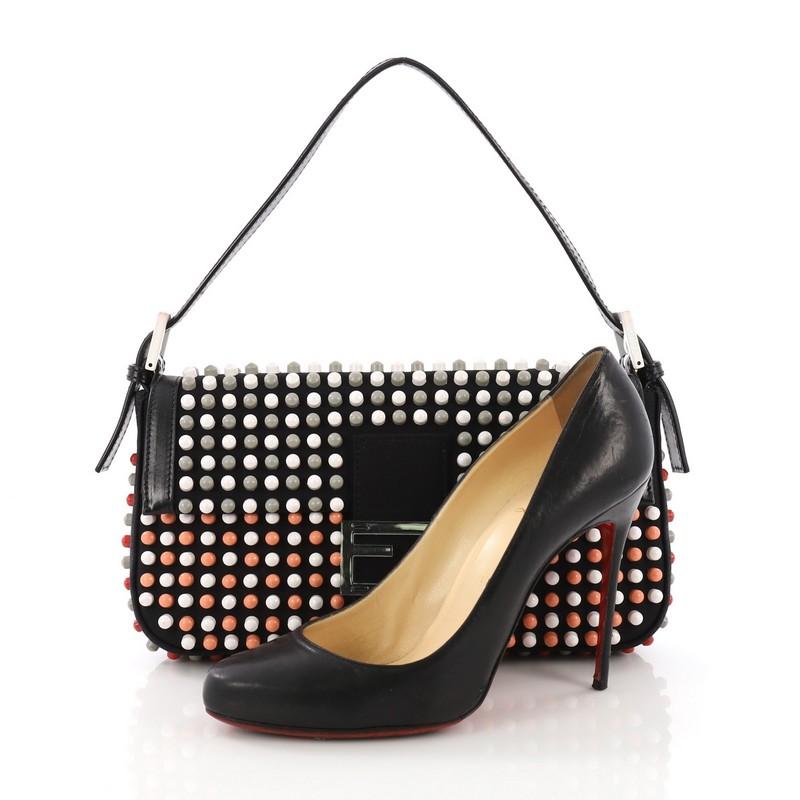 This Fendi Baguette Studded Neoprene, crafted from black studded neoprene, features a flat shoulder strap and gold-tone hardware. Its magnetic lock closure opens to a beige canvas interior with zip pockets. **Note: Shoe photographed is used as a