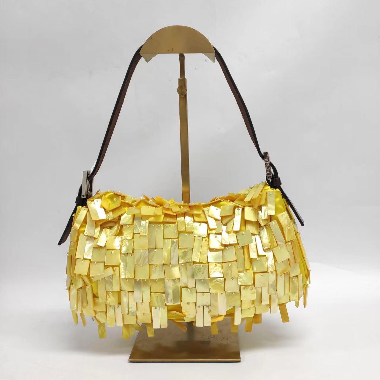 Make a statement with this bold, ultra-rare Fendi Baguette. Boasting yellow silk and a dazzling display of mother-of-pearl sequins, it'll take your look to the next level with its daring style! Be a fashion icon today!

Very good condition. Most