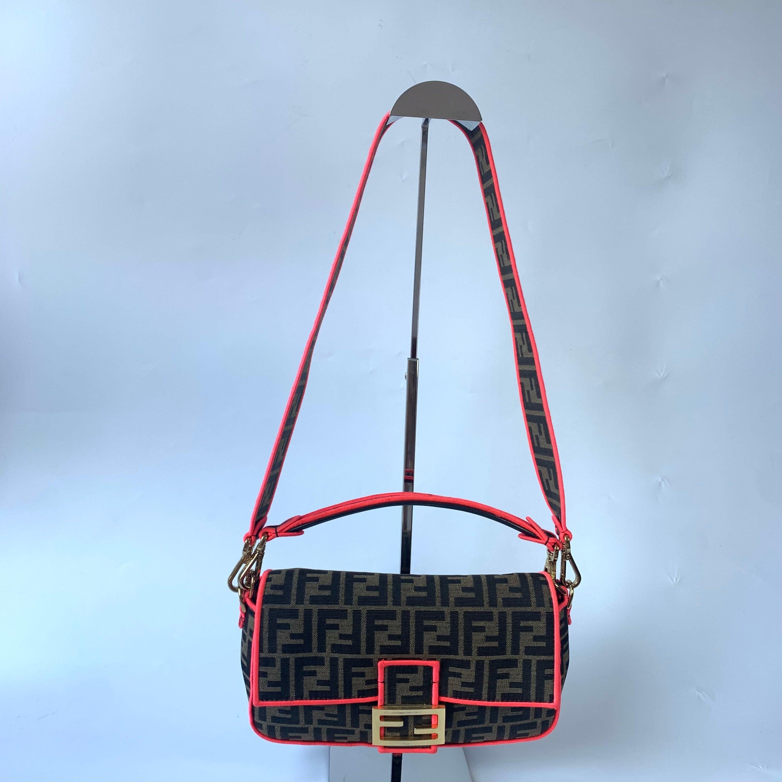 FENDI Baguette Zucca Monogram Canvas with Pink Neon trimming Crossbody Bag
These are professional photos of the actual bag.
  Fendi Baguette in Brown Zucca print canvas with electrifying neon color trimming. 
  CONDITION: EXCELLENT
  Handbag has