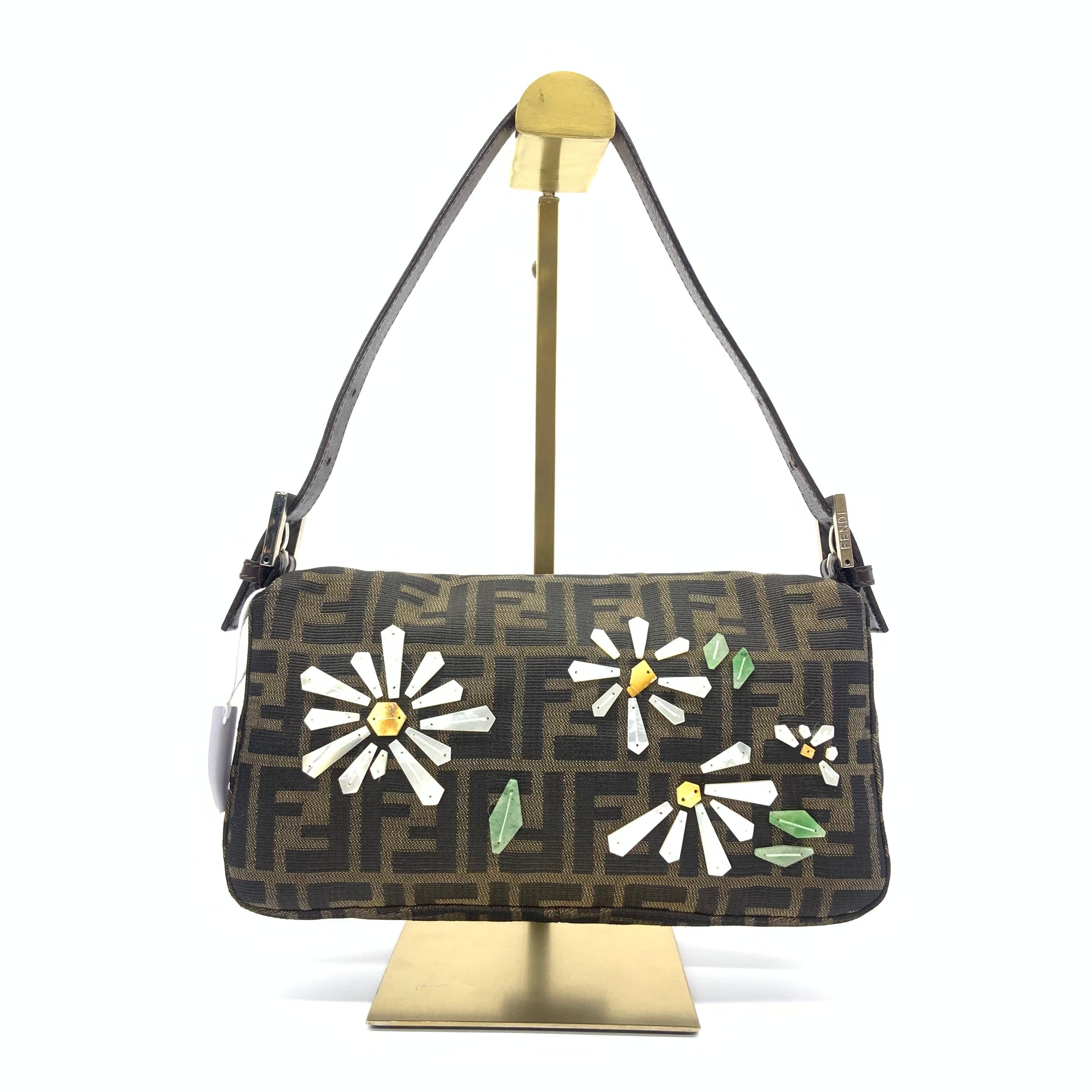 Fendi Baguette Zucca Monogram with Shell Floral Embroidery
These are professional photos of the actual bag.
  Made from the highest quality materials, this Fendi baguette is a luxurious choice for any fashion-forward individual. Beautifully designed