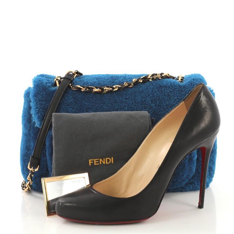 This Fendi Be Baguette Shearling Medium, crafted from blue shearling, features a woven-in leather chain strap with shoulder pad, exterior front pocket with FF logo, and gold-tone hardware. Its top flap frontal push-lock closure opens to a black