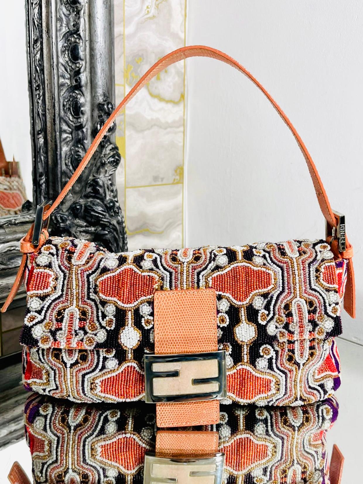 Fendi Beaded & Lizard Skin Baguette Bag

From the 190's  is this rare bag which is fully adorned with orange, black and white  beading. Flap front with magnetic closure and peach toned lizard skink accents and strap. Silver hardware. Vintage. 

Size