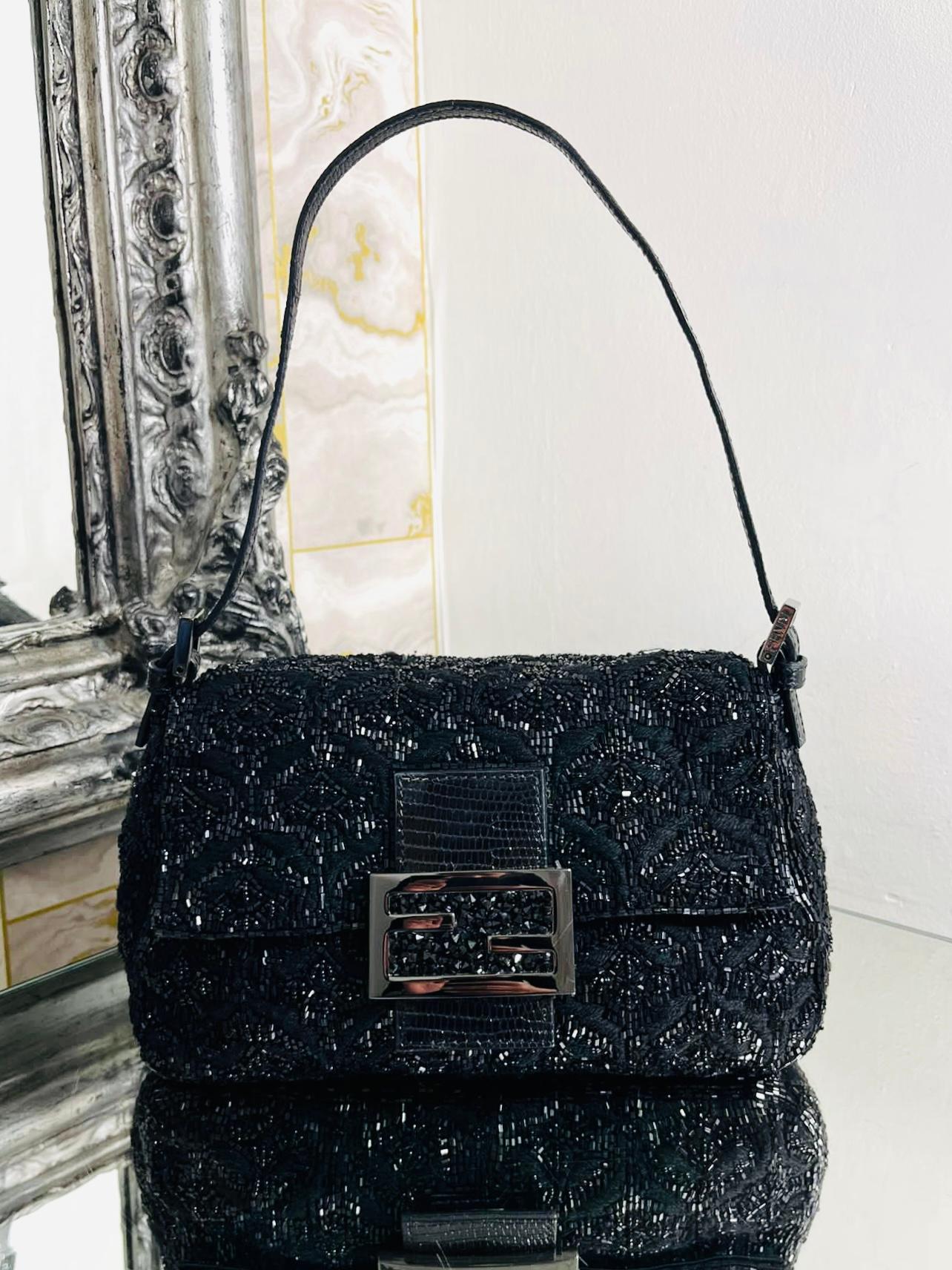 Fendi Beaded Mama Baguette Bag

Black bag which is fully adorned in fancy black beading pattern.

Black lizard embossed closure with large FF logo. Shoulder stap 

and silver hardware.

Size - Height 16cm, Width 21cm, Depth 10cm

Condition - Vintage
