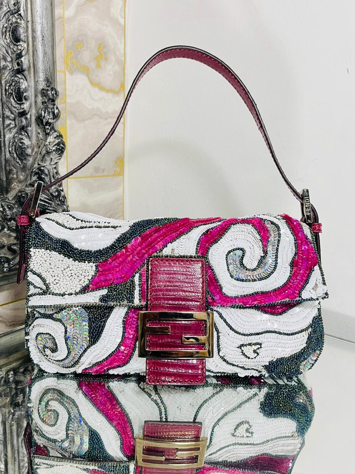 Fendi Beaded & Sequin Baguette Bag

Created by Silvia Venturi Fendi in 1997, is this rare bag which is fully 

adorned with pink, black and white beads and sequins. Magnetic closure

flap with pink snake skink accents and strap. Silver