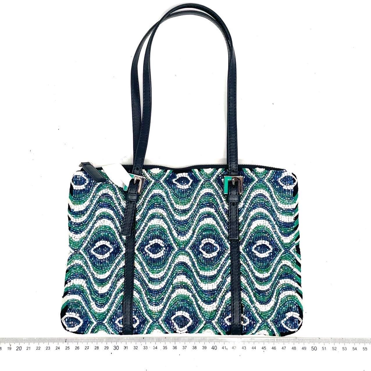 ÉTAT : EXCELLENT

Il peut manquer quelques perles par endroits mais l'ensemble est en excellent état. 

DÉTAILS

Fendi
Sac à bandoulière / Fourre-tout

Perles multicolores
Doublure en satin vert
Sangles en cuir noir
Matériel argenté

Largeur 25cm x