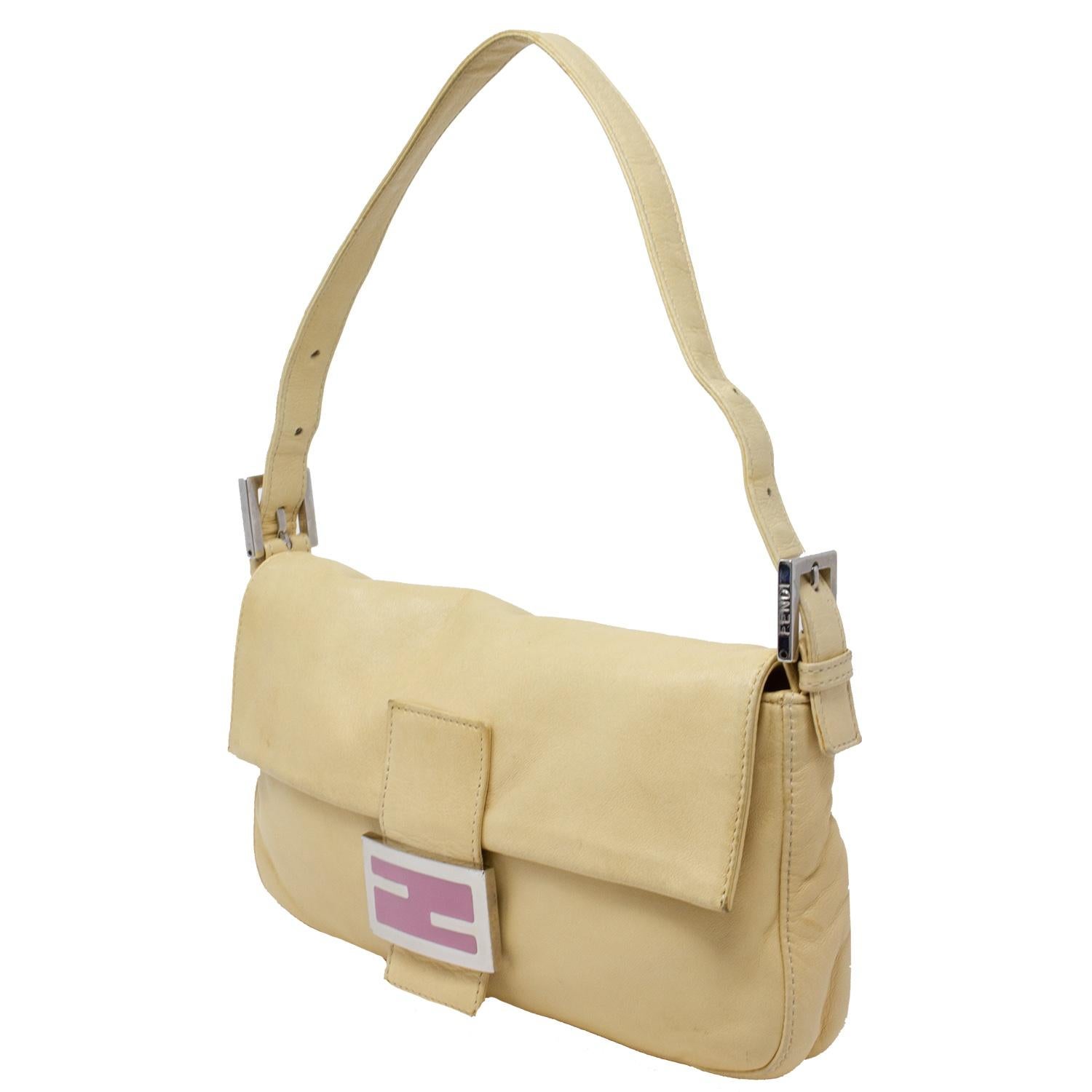 RARE and perfect color combo Fendi Baguette. We love the tones. In beige soft lambskin leather with a light pink logo plate, the front magnetic snap closure opens up to to a satin pink lining with a single zip pocket. The logo plate is gorgeous and