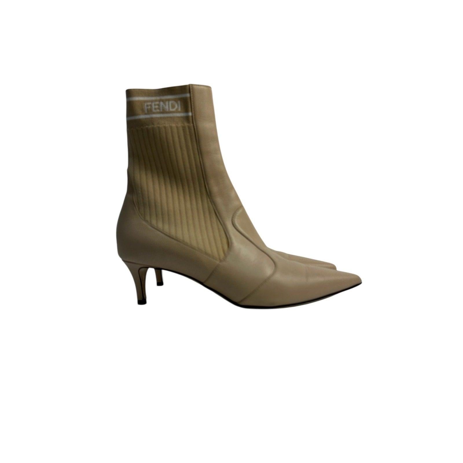 Step out in style with these Fendi beige ankle boots! 
These elegant boots feature a smooth leather construction complemented by stretch-knit panels, ensuring a snug and contoured fit. 
The pointed toe and low kitten heel create a refined