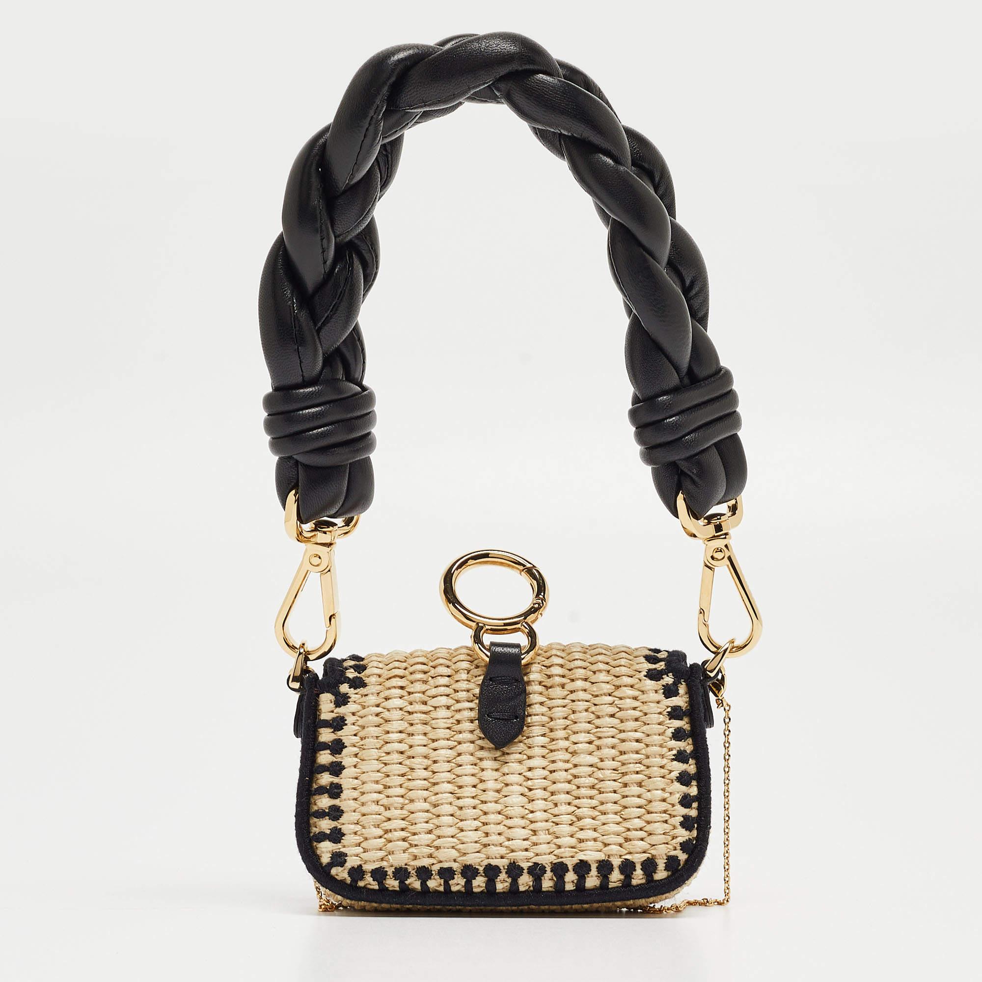 Presenting the Fendi charm, a delightful fusion of textures and tones. Crafted with meticulous detail, this miniature marvel features a blend of raffia and leather, exuding understated luxury. Its compact design is perfect for adding a touch of chic
