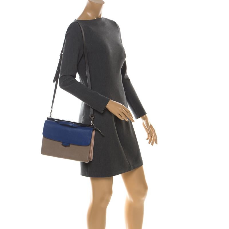 This Demi Jour bag by Fendi is not only lovely to look at, but is also handy and durable. It has been crafted from beige and blue leather and styled very artistically with a flap compartment in the front and a zipper one at the back. The insides are