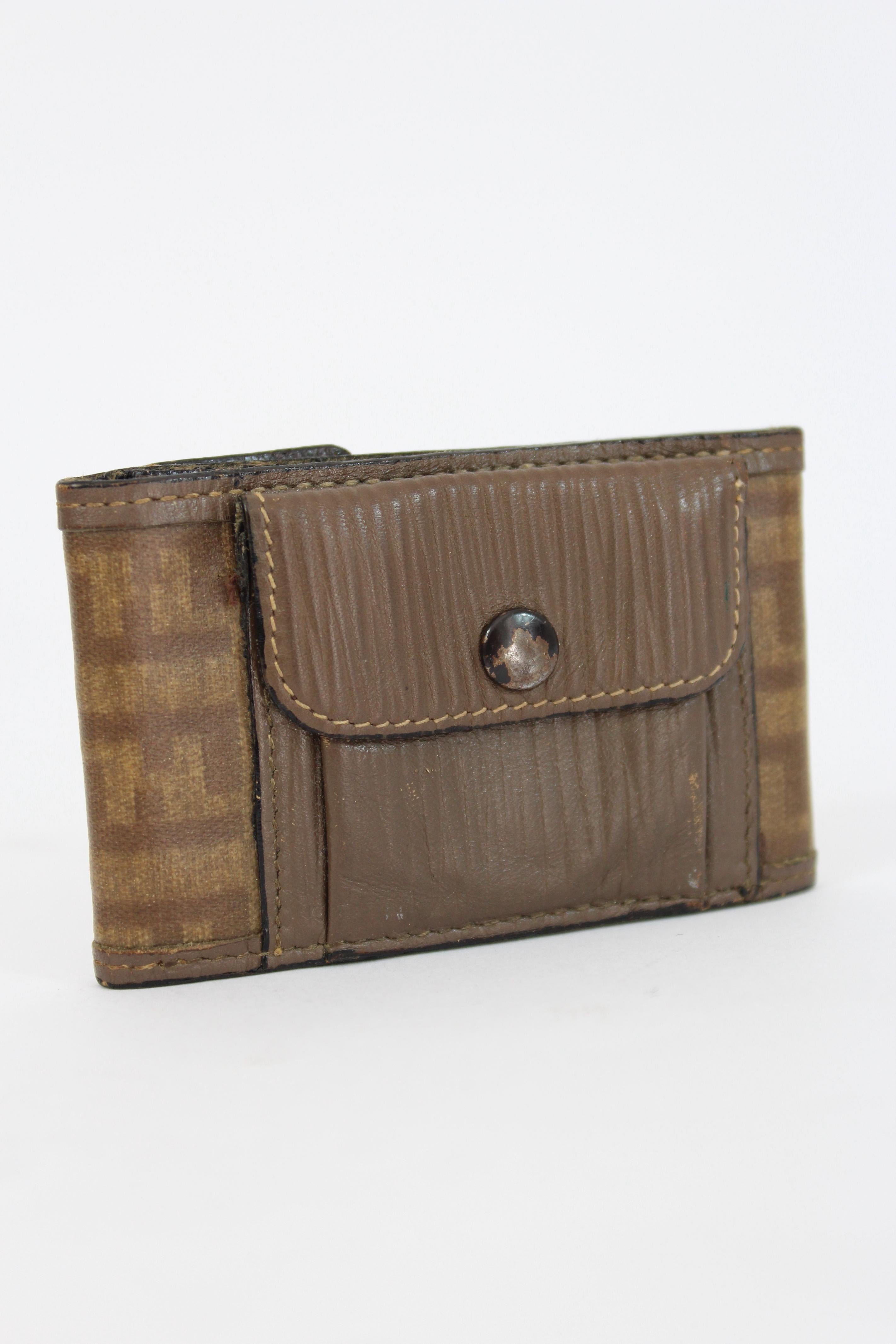 Fendi vintage wallet 70s. Small wallet, with compartment for paper coins and pocket. Monogram pattern in beige and brown color. Fabric, leather and canvas. Closure with clip buttons. Made in Italy.

Condition: Very good

Item in excellent condition.