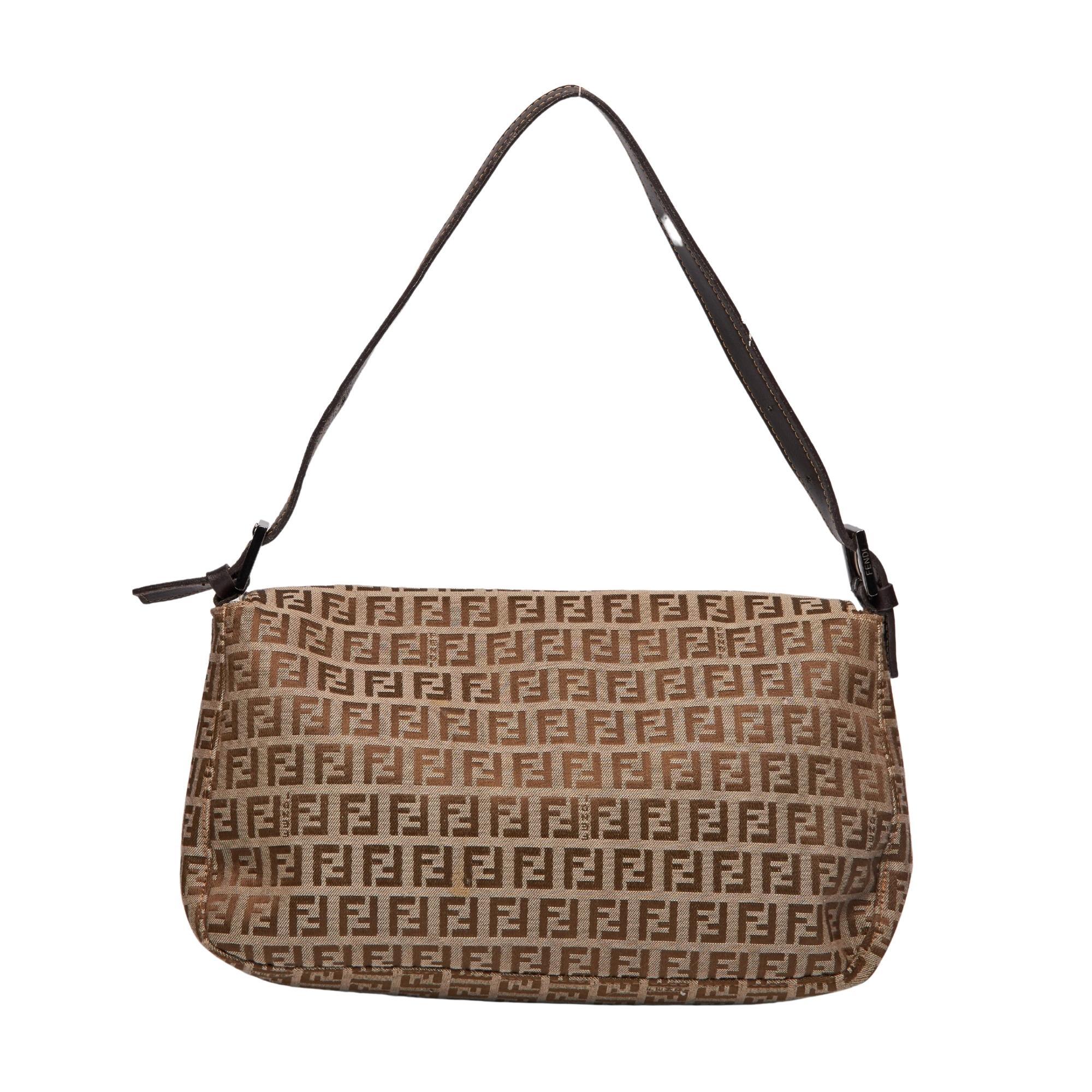 
This Fendi Beige/Brown Zucca Canvas Baguette Bag features beige and brown Zucca Canvas, a Fendi Forever clasp at the center, a removable flat leather shoulder strap and cloth interior lining.

COLOR: Beige/brown
MATERIAL: Canvas
MEASURES: H 8” x L