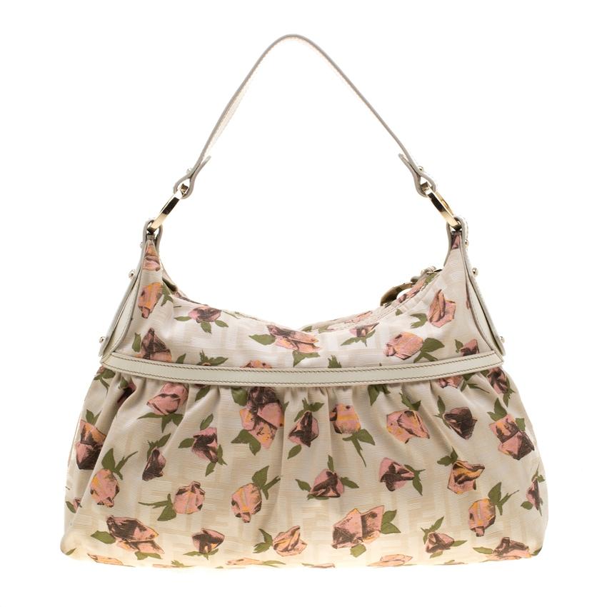 This chic and feminine Chef shoulder bag is from Fendi. The bag is made from tobacco Zucca canvas and is styled with leather trims and a lovely floral print. The bag features a shoulder handle, a Fendi charm and a fabric lined interior which will