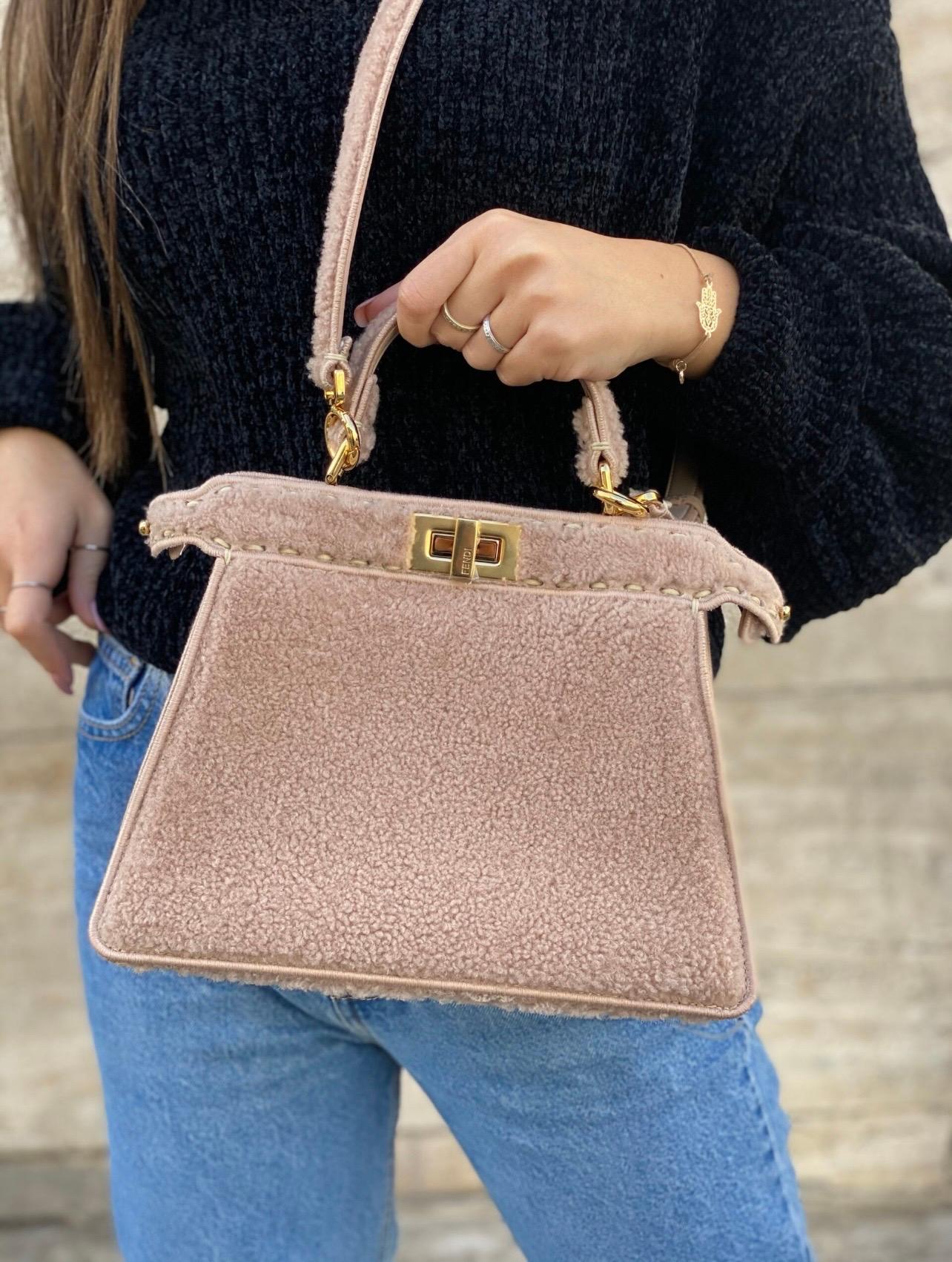 Fendi Peekaboo Small edition bag made of soft beige merino sheepskin and golden hardware.The bag features two side openings with the iconic Fendi swivel closure. The interior is divided into two different compartments, both of which are lined with a