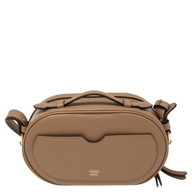This Fendi camera bag is a timeless piece that can last you season after season. This bag is made of leather as well as suede and will suit all your needs. It has a beige shade, a long shoulder strap, top handle, canvas-lined interior, logo