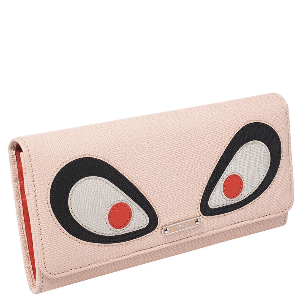 Crafted from beige leather, this Fendi Monster Eyes wallet has signature eye detailing on the flap. Its interior is lined with leather & fabric and houses two bill slots, multiple card slots, and a dividing coin pocket.

