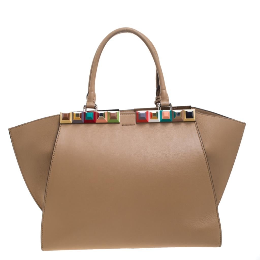 Fendi brings you this stunning update of their famous 2jours bag, the 3Jours! Crafted from leather, the beige bag has two handles and a gorgeous embellished bar on top that is split down the middle. The insides are leather-lined and spacious enough