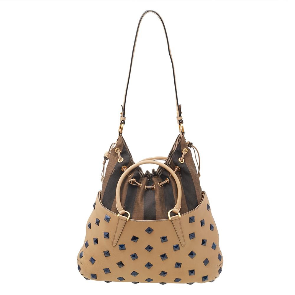 This Fendi tote is truly a work of art. The bag has a beige leather exterior with stud embellishments, two hands, and a shoulder strap. It has an expandable interior lined with fabric. An everyday must-have!

Includes: Original Dustbag