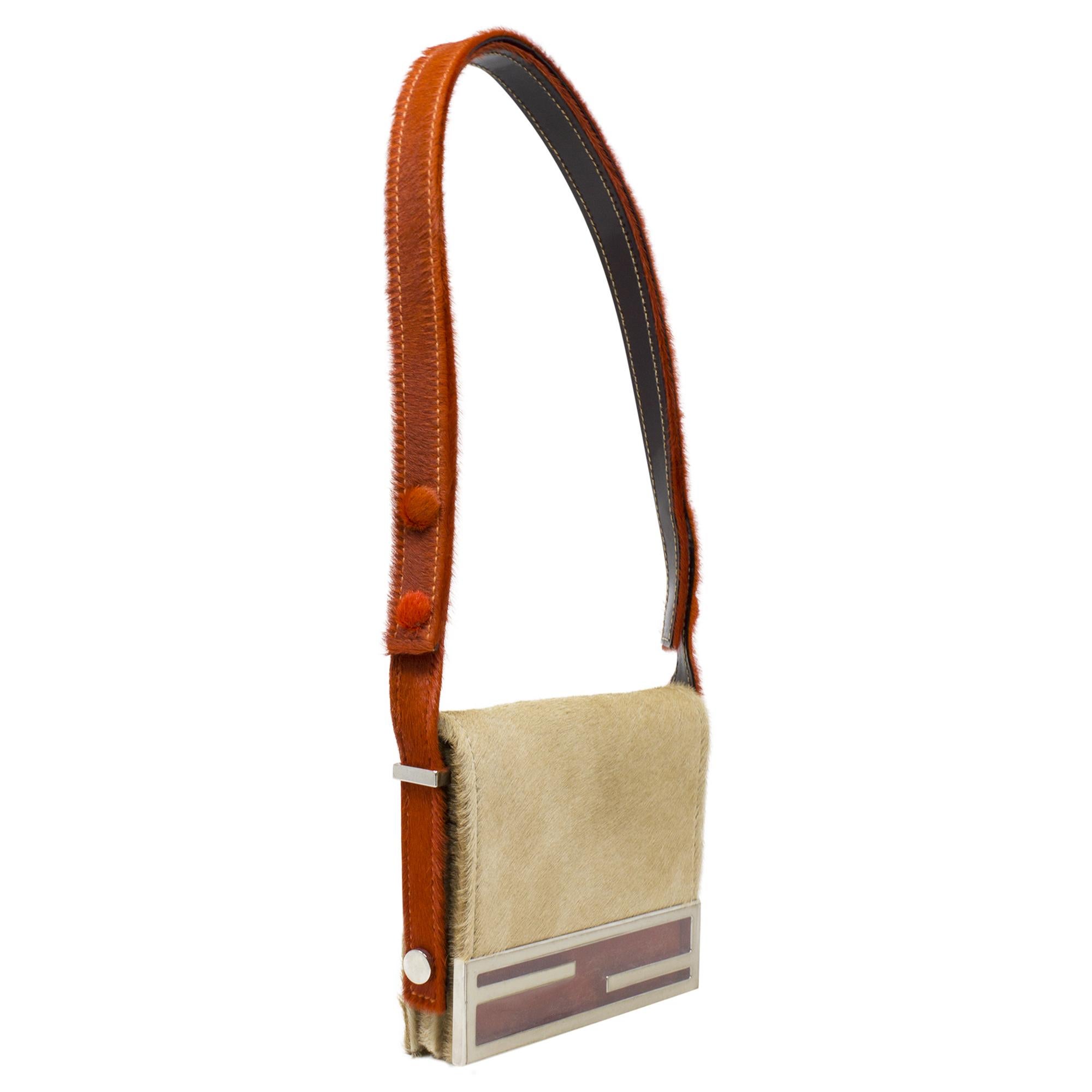 Introducing the Fendi Beige Logo Pony Hair Crossbody, a chic accessory for the fashion-forward individual. Crafted from luxurious beige pony hair fur adorned with Fendi's iconic logo print, this crossbody bag exudes elegance and sophistication. With