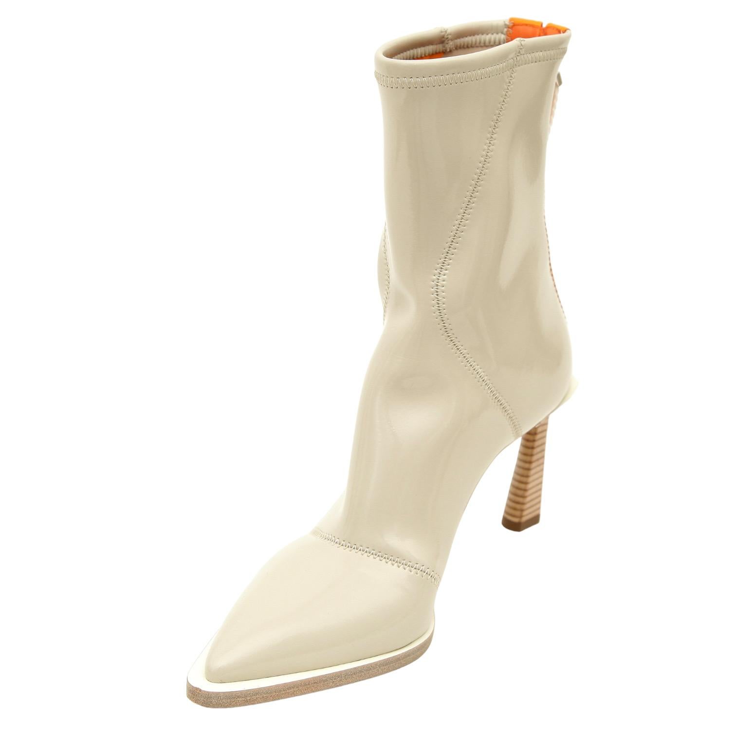 GUARANTEED AUTHENTIC FENDI FFRAME NEOPRENE ANKLE BOOTS

Details:
- Beige neoprene uppers in a glossy beige.
- Orange stripe.
- Back zipper closure.
- Pointed toe.
- Wood heel.
- Leather soles.
- Comes with designer dust bag.

Size: 38

Measurements