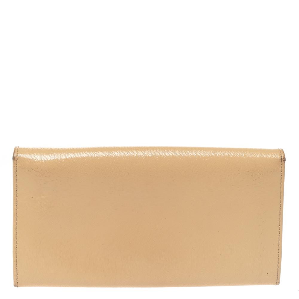 Carry your bills and cards in this Fendi wallet. The beige patent leather exterior is accented with a gold-tone brand logo the front flap which opens to a leather and fabric-lined interior. The interior houses multiple card slots and a zipped