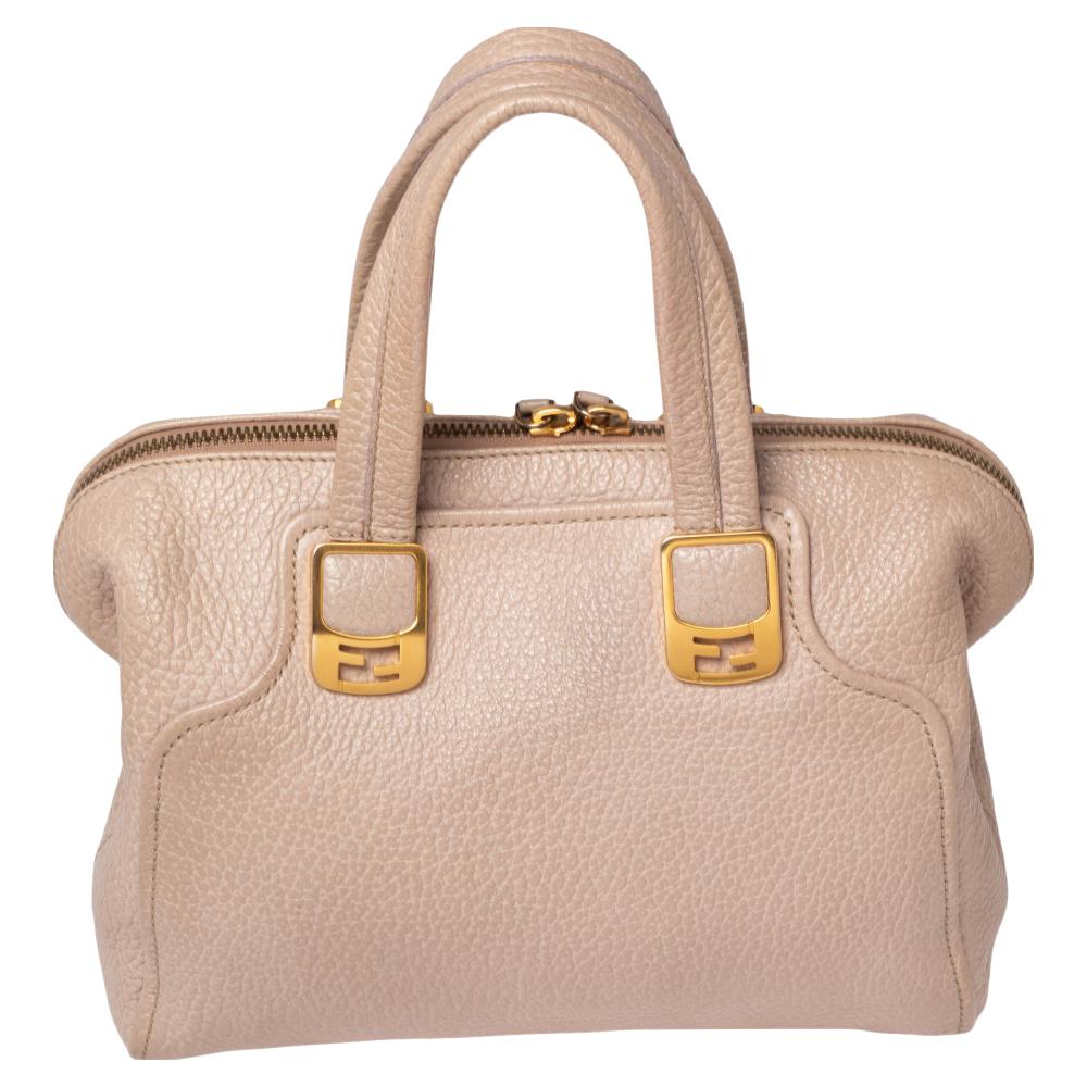 The Chameleon satchel from the House of Fendi is here to add uniqueness and extravagance to your collection. It is designed skillfully using beige pebbled leather on the exterior. The satchel is embellished with gold-toned fittings, a shoulder
