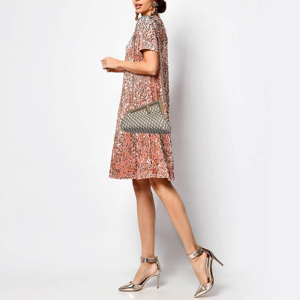 The Fendi shoulder bag is a chic and compact accessory crafted with precision. Its intricate woven design showcases a blend of beige and white tones, elevating its sophisticated aesthetic. The small size makes it perfect for on-the-go elegance,
