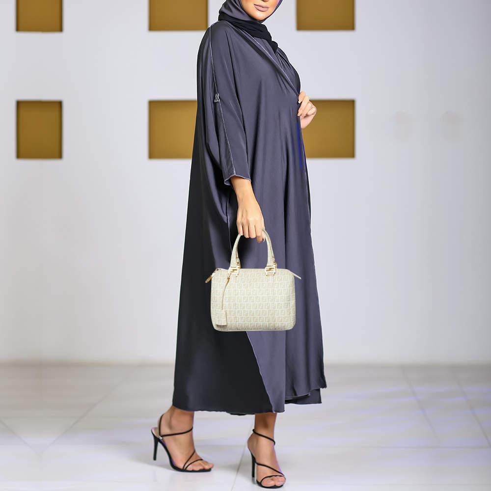 This Forever Bauletto Boston bag from Fendi is the perfect bag youve been searching for  all this while The beige creation is crafted from Zucchino coated canvas and leather and features dual top handles that are detailed with gold tone brand logo